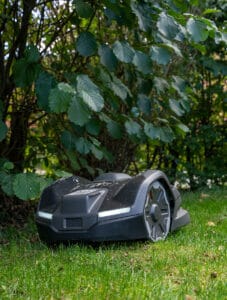 Husqvarna Automower 410XE Nera klipper nära buskar