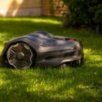 Husqvarna Automower 410XE Nera en solig dag mitt på gräsmattan